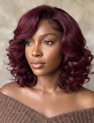 A woman with a burgundy curly wig