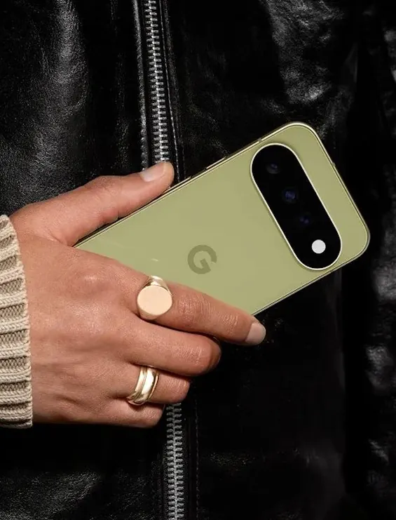 A hand holding a green Google Pixel phone against a leather jacket